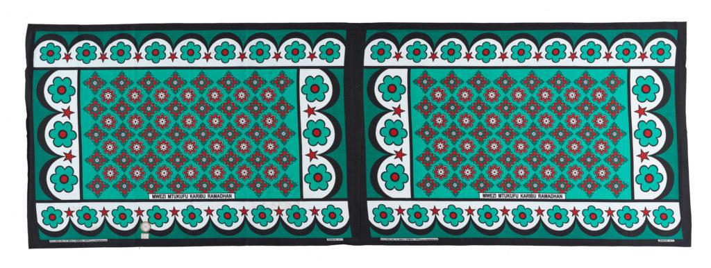 two kangas with a green, black, white and red floral pattern