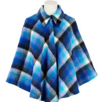 A woman's cape coat made out of checked blue, white and black woollen blanket material