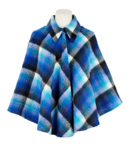 A woman's cape coat made out of checked blue, white and black woollen blanket material