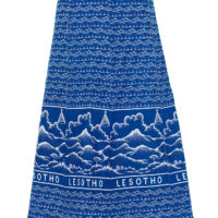 A woman's A line skirt made of blue shweshwe fabric, featuring the word 'Lesotho'