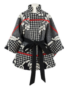 A woman's cape coat made from a black, white and red woollen basotho blanket.
