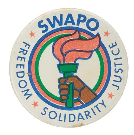 Round white pin badge with an illustration of a hand holding a lit torch.