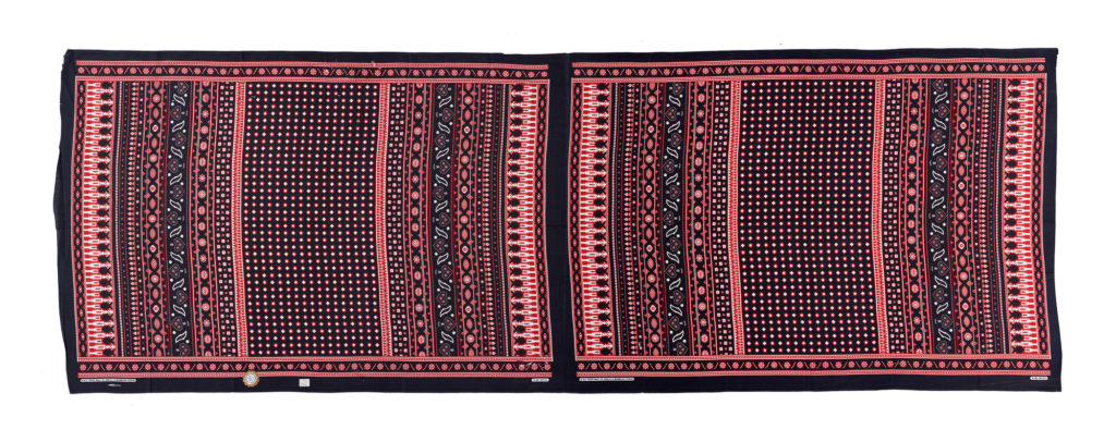 Unseparated pair of kangas in a traditional design with no slogan, in Red, black, and white.