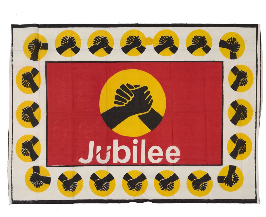 red, white, yellow and black cloth with two clasped hands and the word jubilee