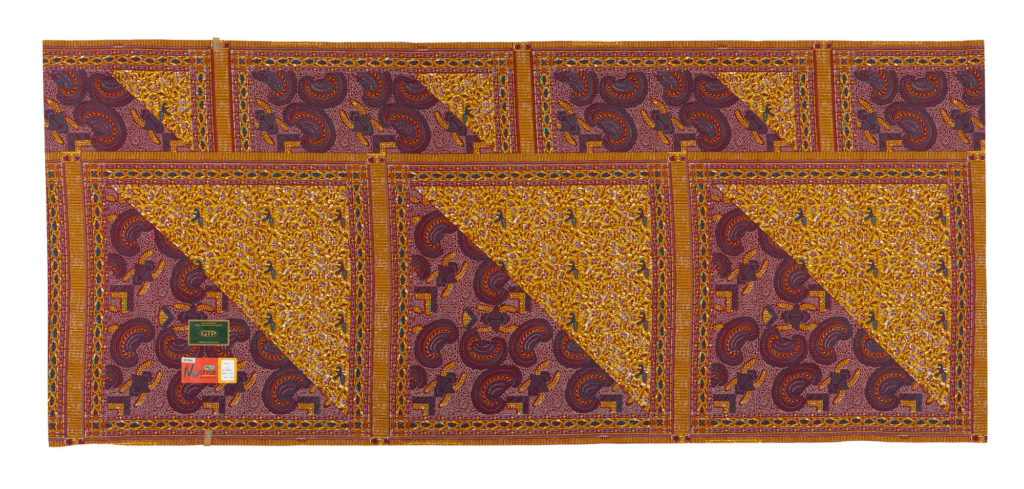 Piece of printed cotton fabric in a purple and orange paisley wax print