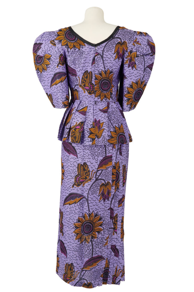 Purple wax print blouse and skirt with sunflower, butterfly and lily motifs.