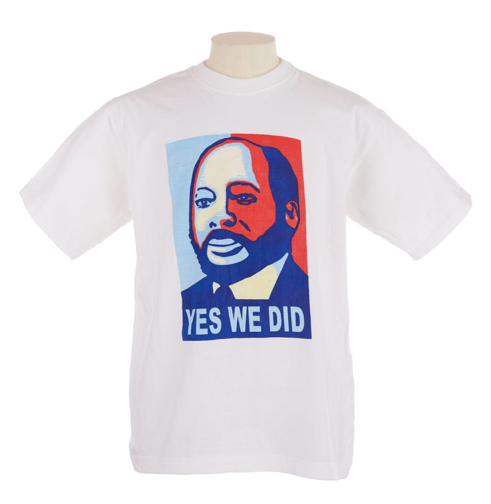 White T shirt with blue and red printed portrait of John Garang de Mabior with the slogan 'Yes We Did',