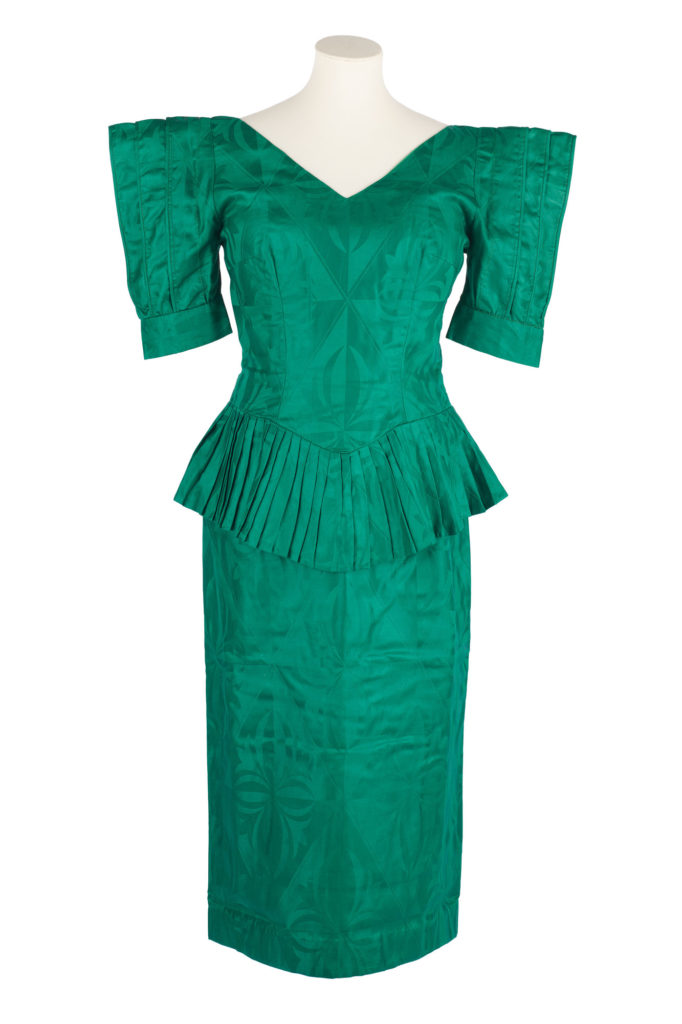 Teal women's blouse and skirt outfit with pointed shoulder pads and pleated peplum waist.