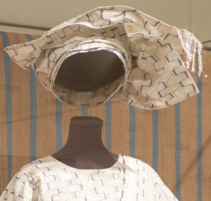white and silver gele headwrap styled on a mannequin