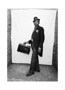 Black and white photograph of man with tailcoats and briefcase