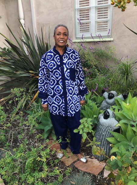 a woman standing in a garden wearing a tie-dyed indigo outift