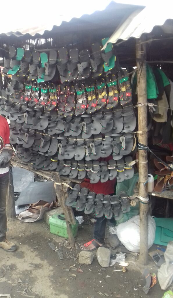 rows of black sandals made of car tyres for sale at a market