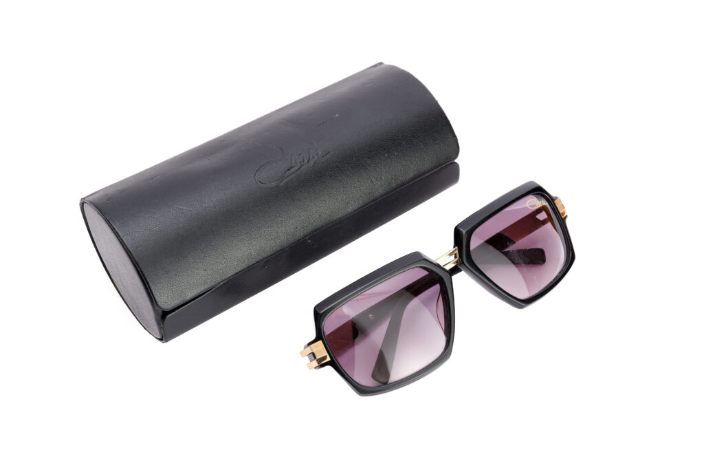 square black rimmed sunglasses next to a black case